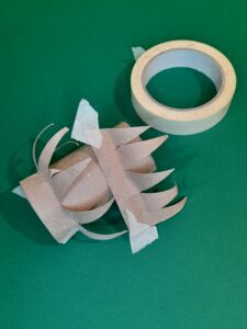 5) With each jagged piece attach with masking tape to the top of the tube to position the spikes.