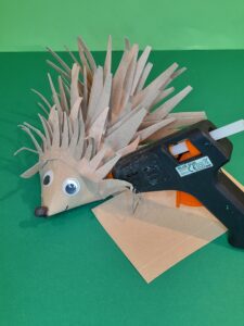 24) Cut out another smaller spikey frill to glue onto the top of head to hide the snips on cone. Curl up small amount of black tissue for the nose and glue on.Stick on googly eyes with small amount of double sided tape., or glue gun.