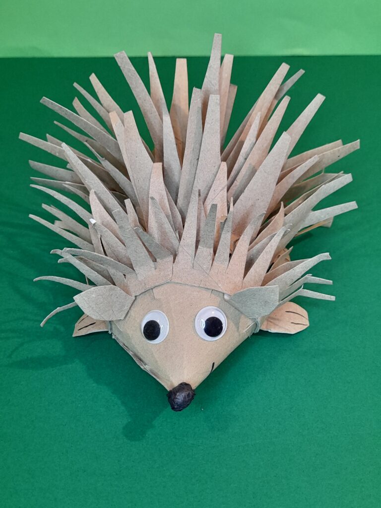 25) Cut out small ears and slide under the frill to hold them in place. When completed this is your raw rustic looking hedgehog.
