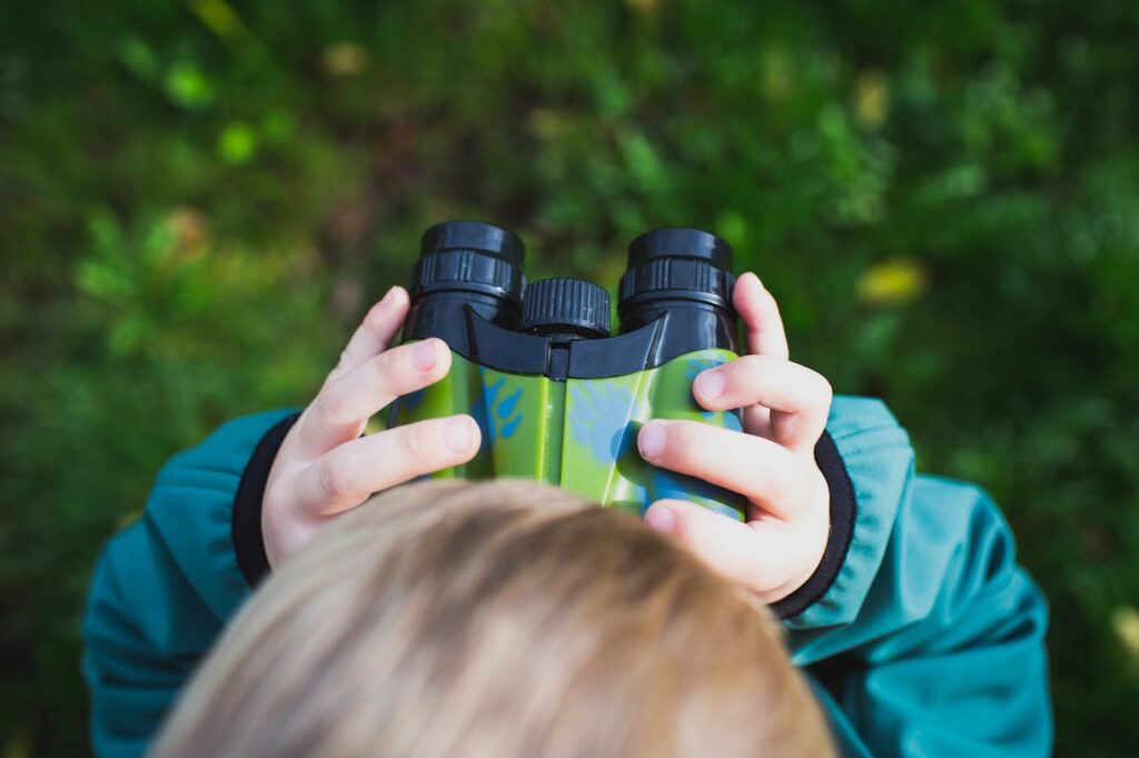 Child looking through binoculars. Pexels picture.