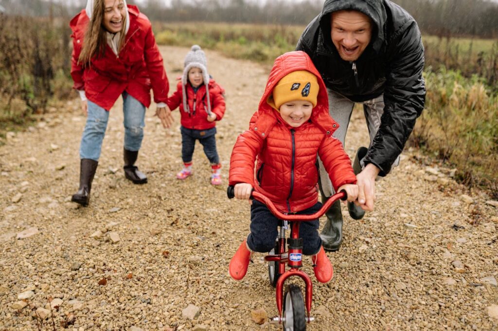 Kids on bike dressed warm. Pexels picture.