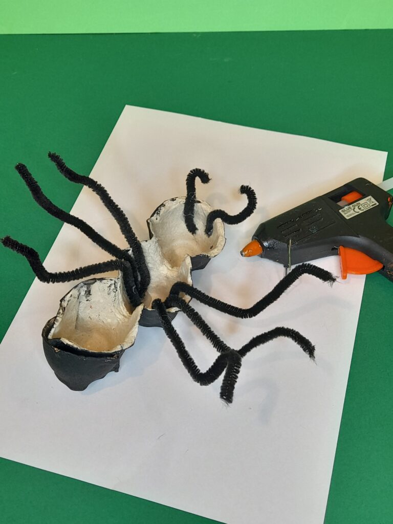 5) Cut in half three black pipe cleaners, turn ant upside down, and hot glue them in the middle of the ant, and cut smaller pieces for the front of the head, these are the mandibles, glue them on as well on the underside of the head. Bend into shape.