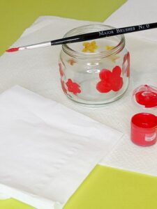Paint red flowers around the jar.