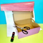 Covering shoe-box with wrapping paper.