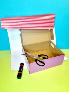 Covering shoe-box with wrapping paper.