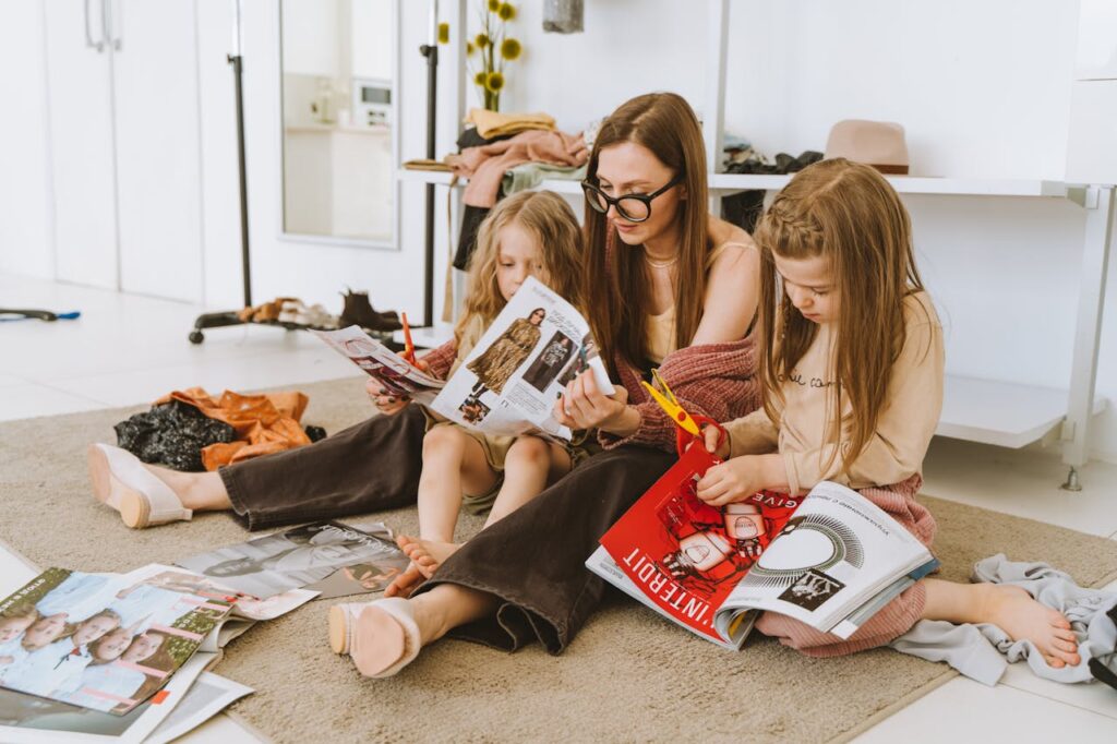 Mum and girls cutting out pictures from magazines. Pexels picture.