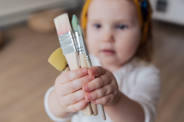 Child with chunky paintbrushes. Easier for kids with additional needs to grasp.