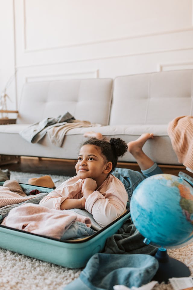 Child packing suitcase. Pexels photo.