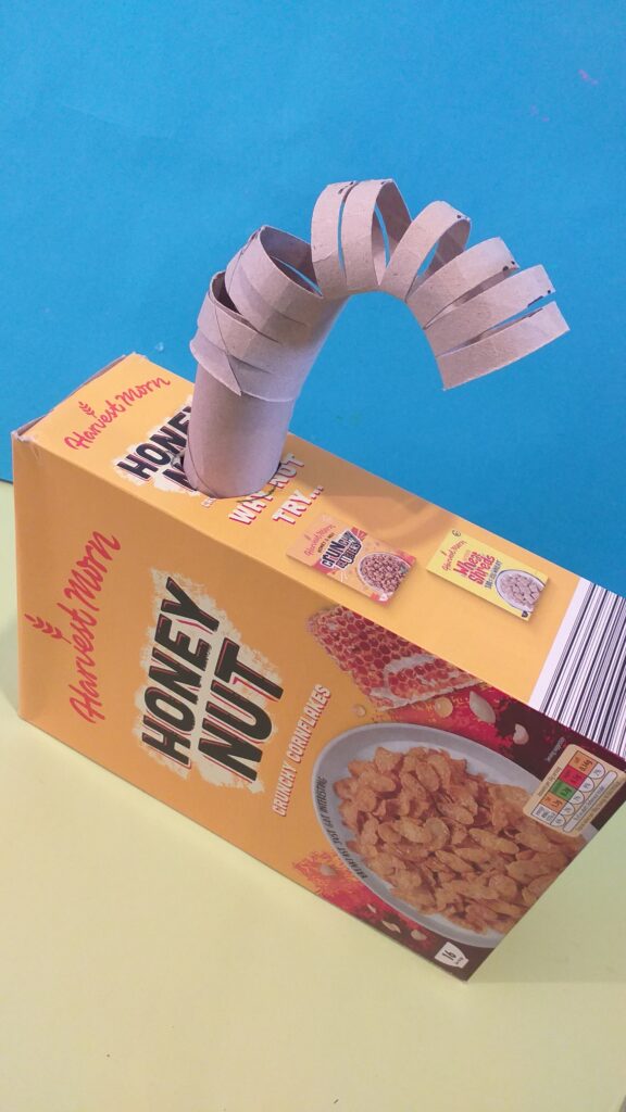 Cereal box for body and cardboard tube for arms.