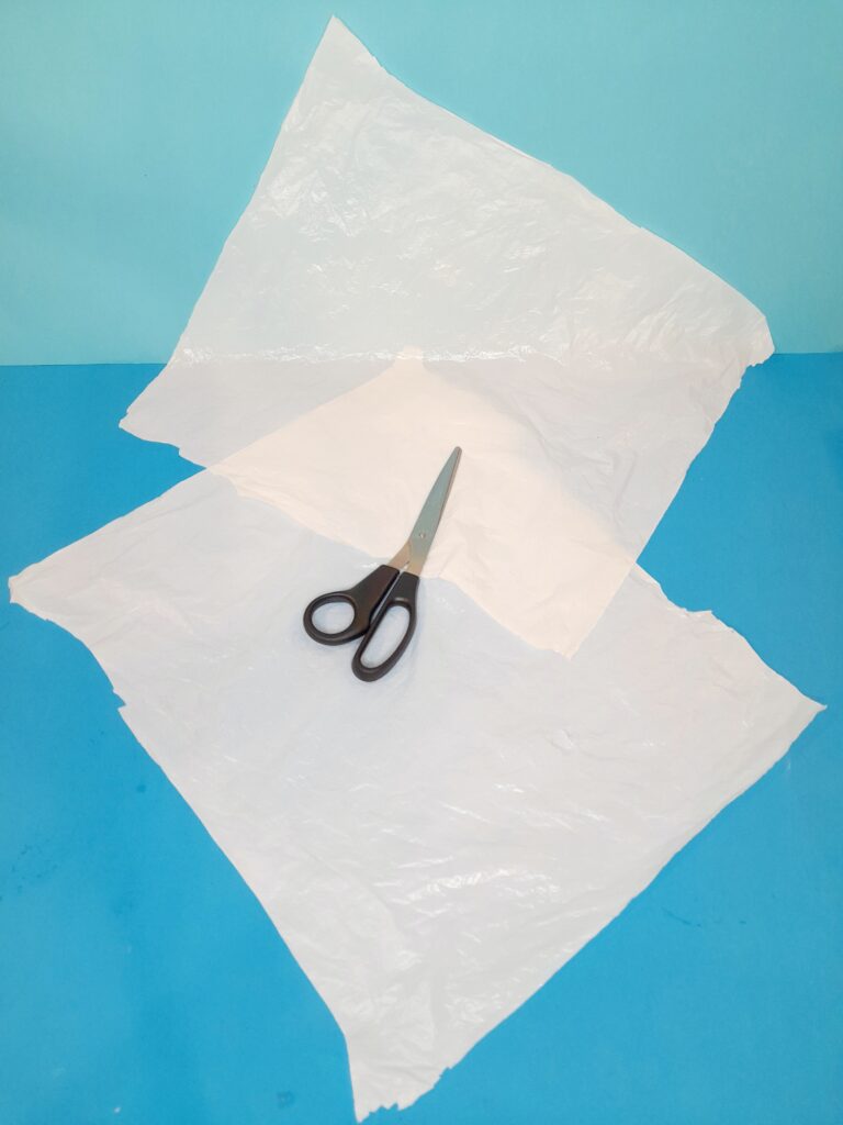 Once the carrier bag has been cut you have 2 square pieces.