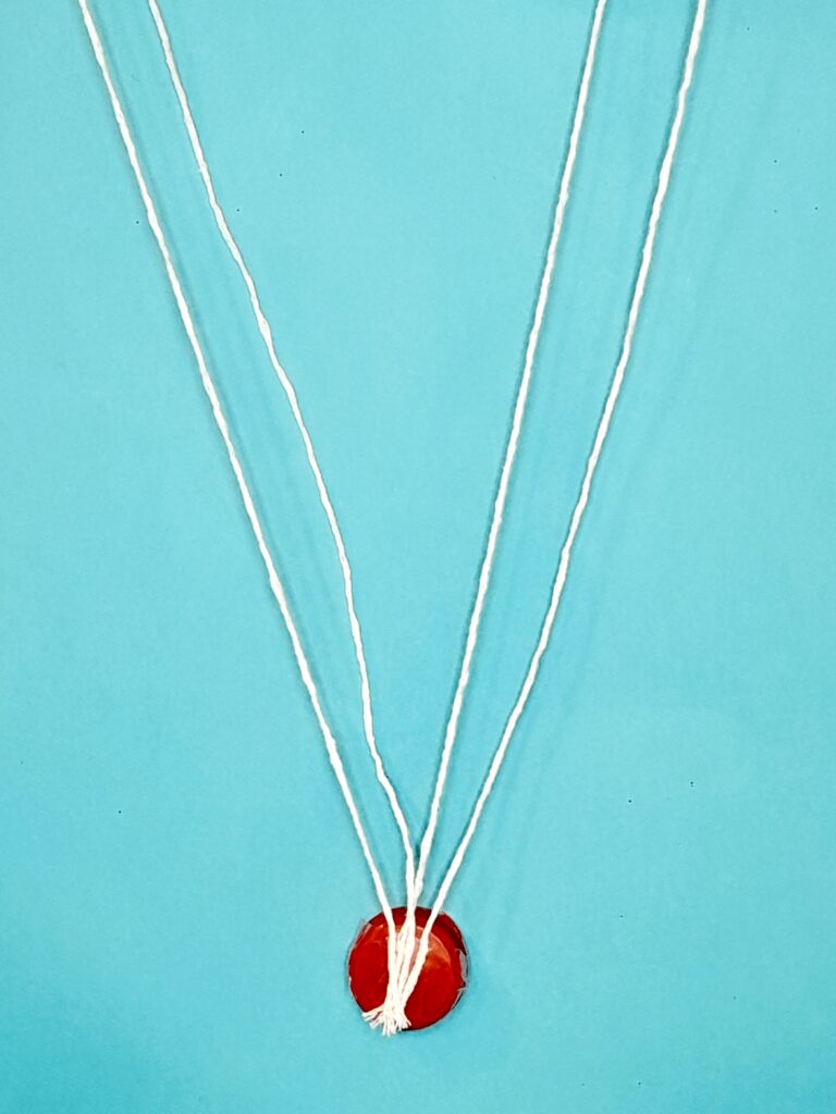 Strands attached to the bottle cap.